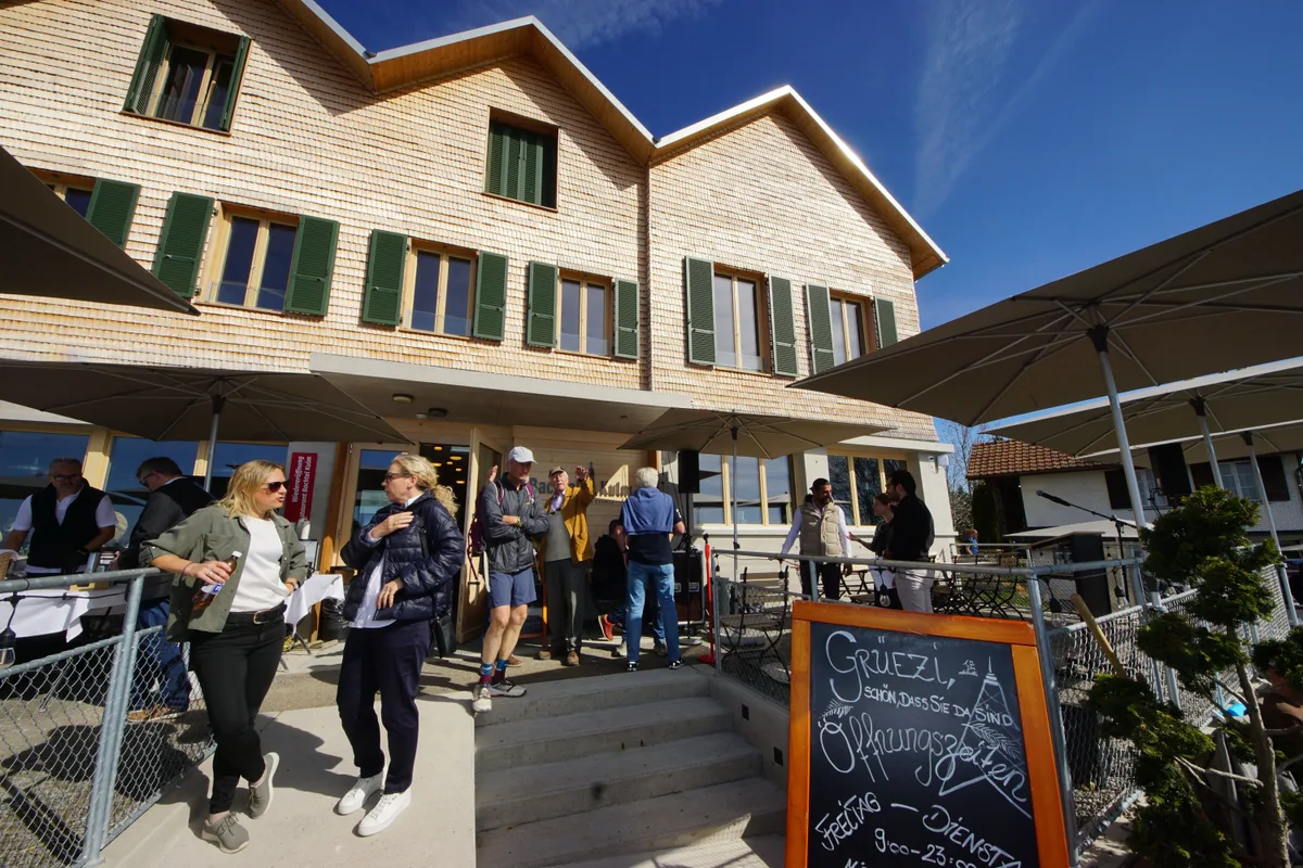 Die Schindel-Fassade gefällt den Besuchern. Leute stehen vor dem Gasthaus Bachtel-Kulm.